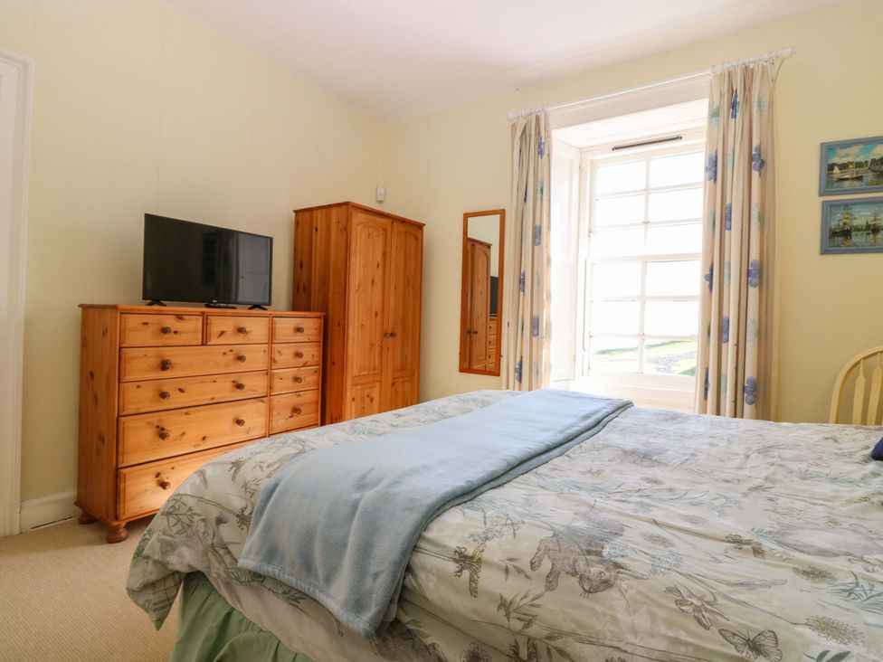 A bedroom with a bed and television at The Lighthouse Retreat in St Abbs