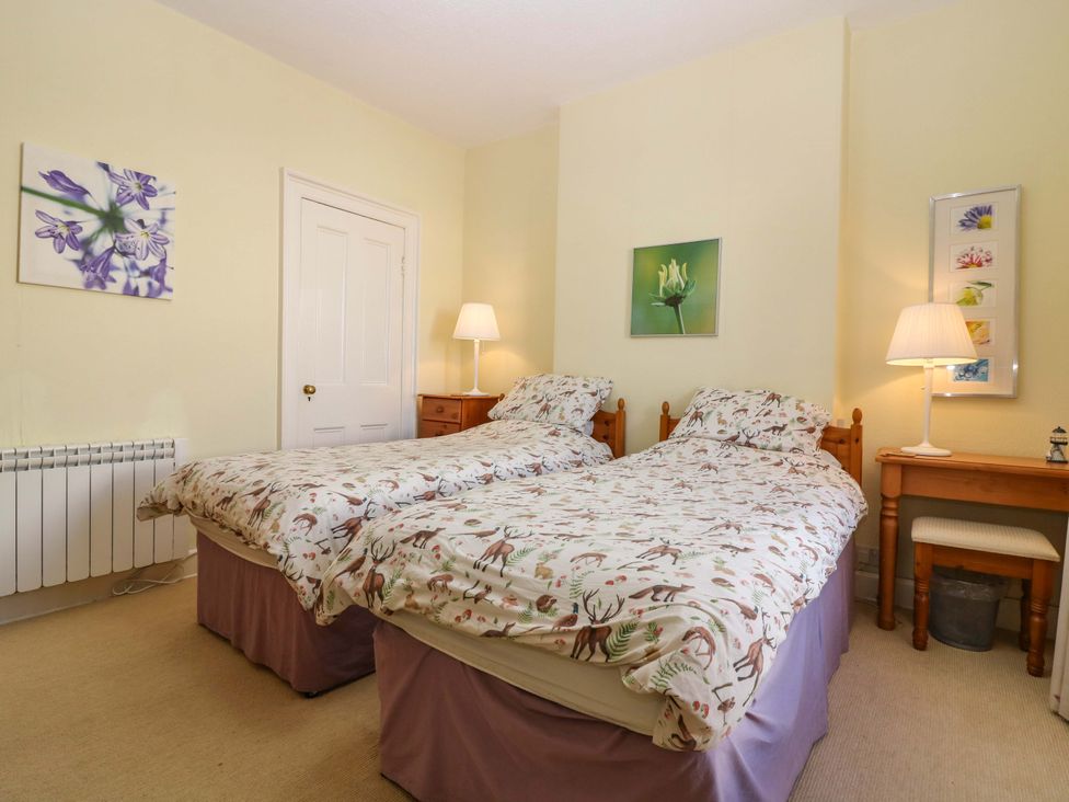 A bedroom with two beds and a nightstand at The Lighthouse Retreat in St Abbs