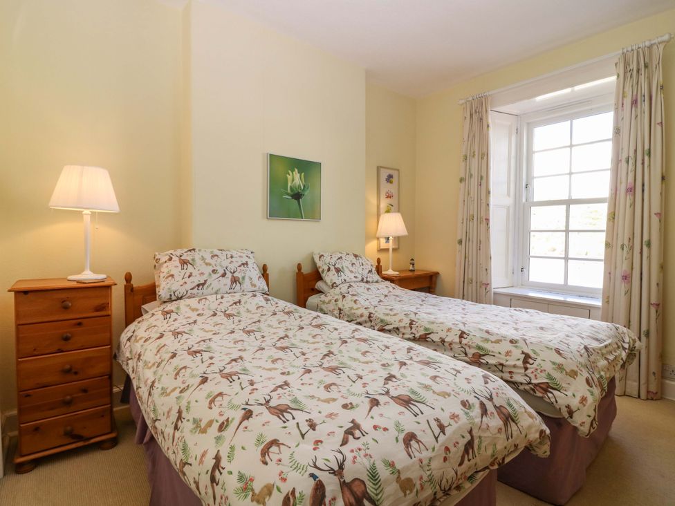 A bedroom with twin beds and a lamp at The Lighthouse Retreat in St Abbs