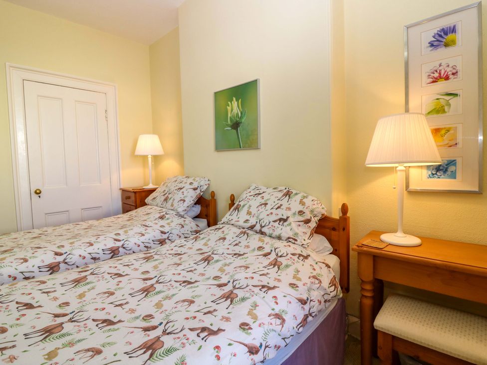 A bedroom with two single beds and a lamp at The Lighthouse Retreat in St Abbs