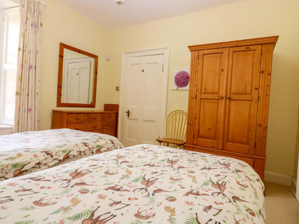 A bedroom with two beds and a wardrobe at The Lighthouse Retreat St Abbs