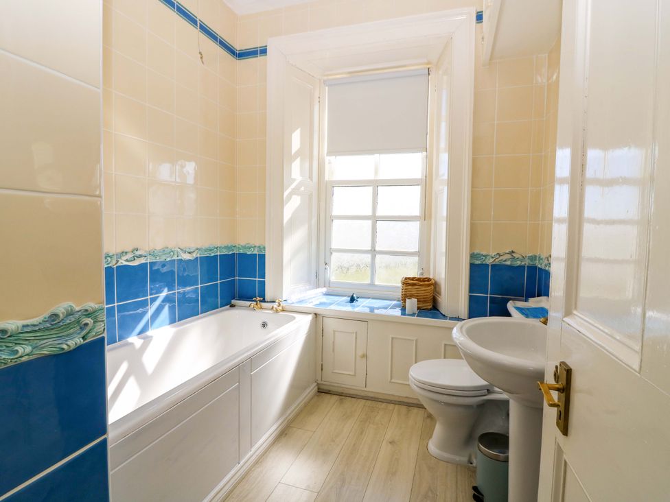 A bathroom with a bathtub, toilet, and sink at The Lighthouse Retreat in St Abbs
