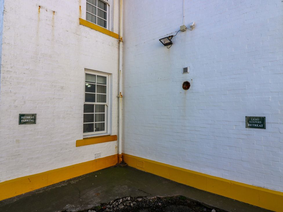 An outdoor area with a wall and signs at The Lighthouse Retreat in St Abbs