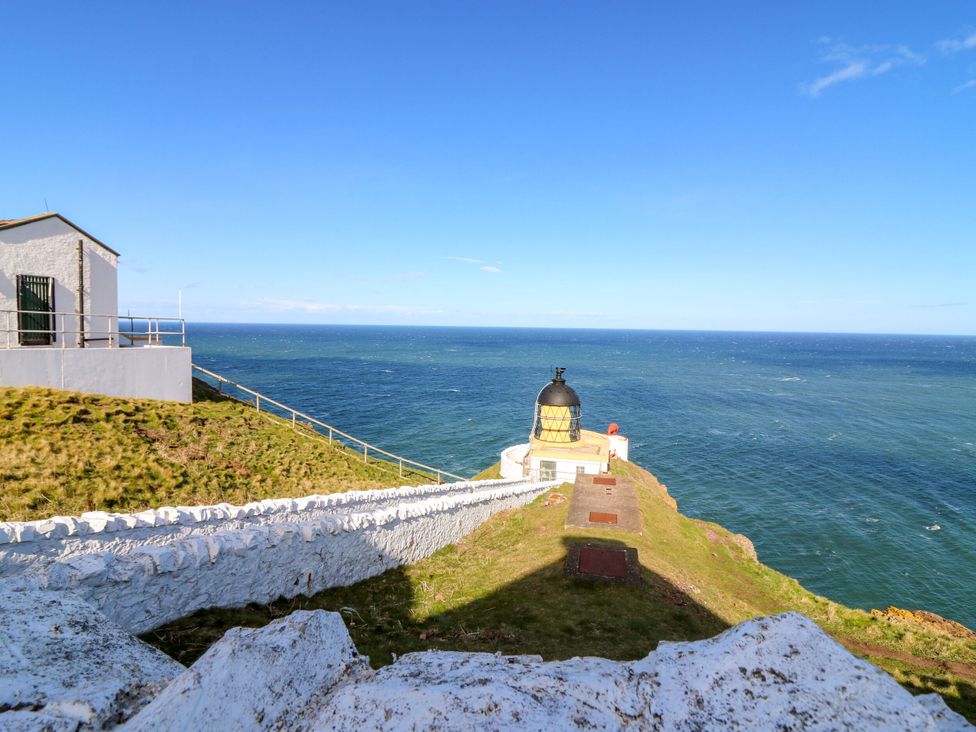 A lighthouse beside the ocean at The Lighthouse Retreat in St Abbs