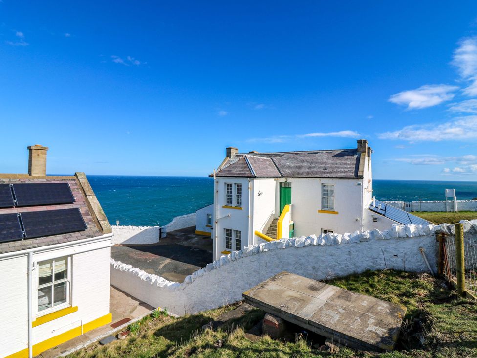 An outdoor view of a house and ocean at Keepers Fold at The Lighthouse St Abbs