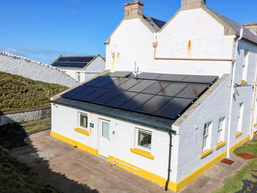 An outdoor view of a white building with solar panels at Keepers Fold at The Lighhouse St Abbs