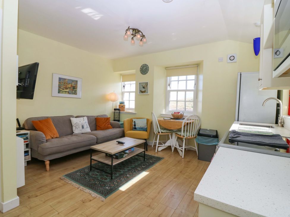 A living room with a sofa and dining table at Keepers Fold at The Lighthouse in St Abbs