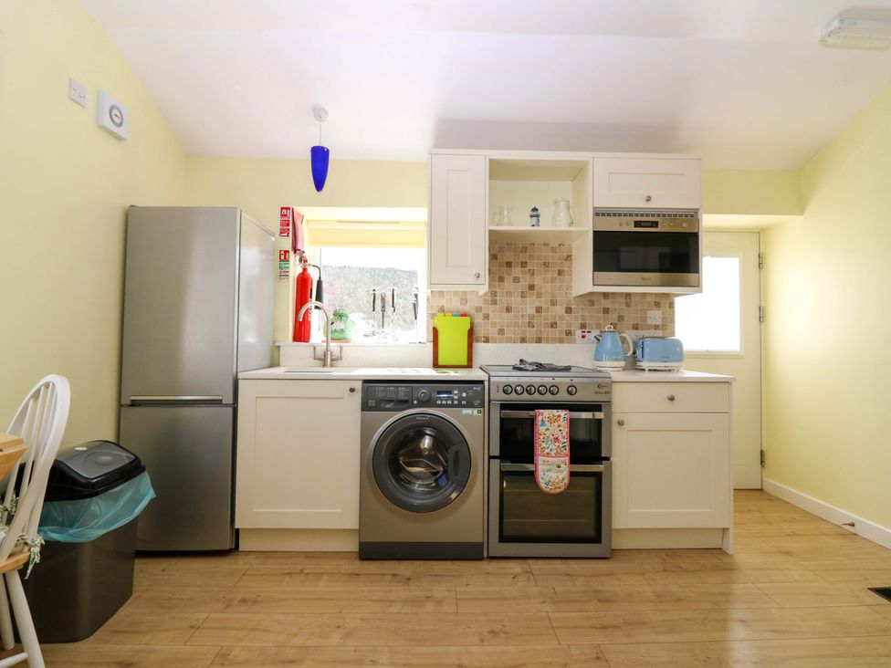 A kitchen with refrigerator, washing machine and stove at Keepers Fold at The Lighthouse St Abbs