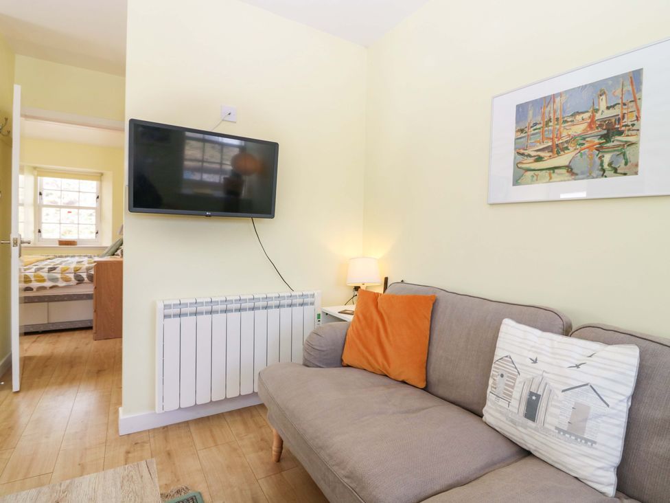 A living room with a sofa and television at Keepers Fold at The Lighthouse St Abbs