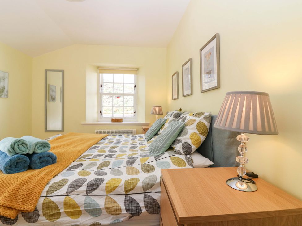 A bedroom with a bed and nightstand at Keepers Fold at The Lighthouse St Abbs
