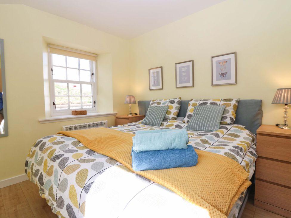 A bedroom with a bed and bedside tables at Keepers Fold at The Lighthouse St Abbs