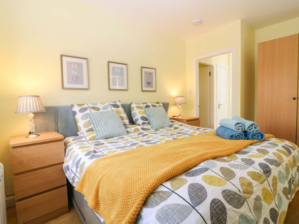 A bedroom with a bed and bedside tables at Keepers Fold at The Lighthouse St Abbs