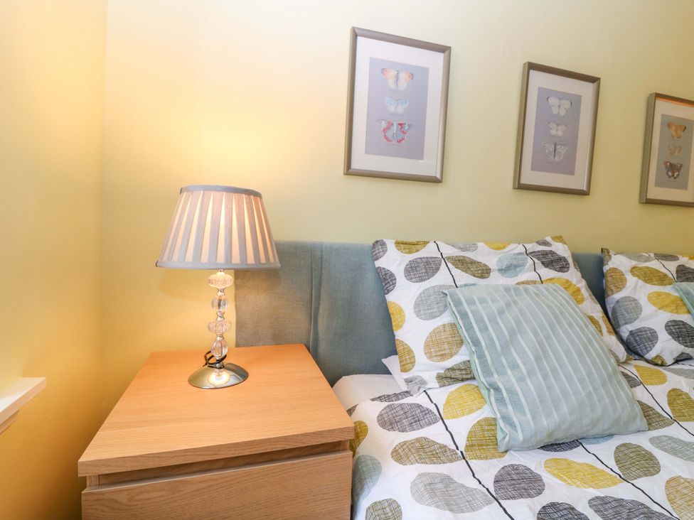 A bedroom with a lamp and artwork at Keepers Fold at The Lighthouse in St Abbs