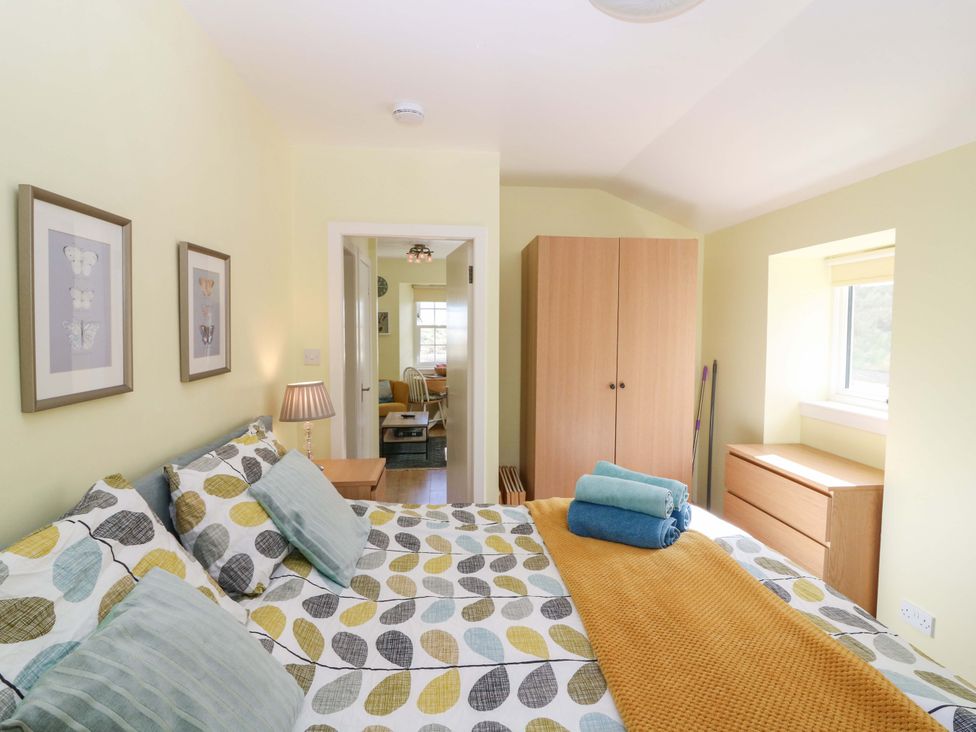 A bedroom with a bed and wardrobe at Keepers Fold at The Lighthouse St Abbs