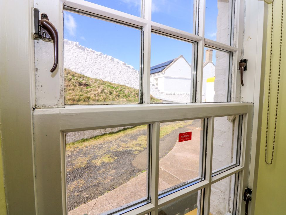 A window showing a grassy area and a pathway at Keepers Fold at The Lighthouse St Abbs