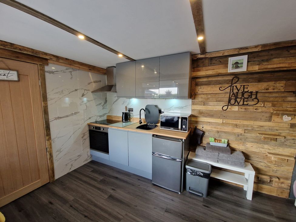 A kitchen with modern cabinets and appliances at Birdsong lodge Hawthorn Farm near Sutton-On-Sea