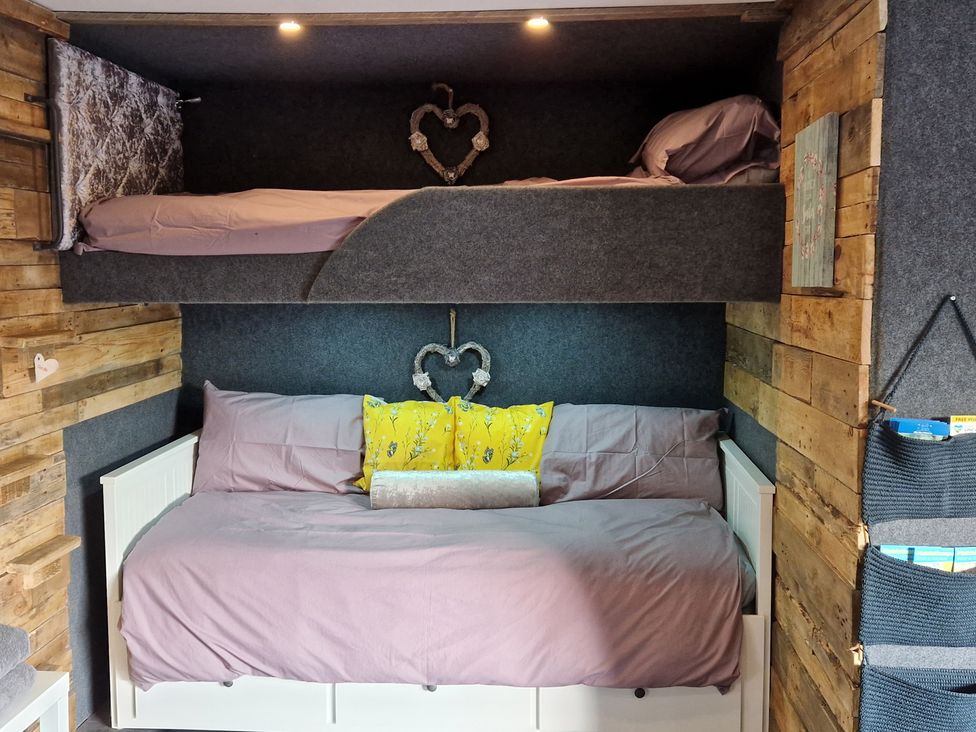 A bedroom with a bunk bed and sofa bed at Birdsong lodge near Hawthorn Farm in Sutton-On-Sea