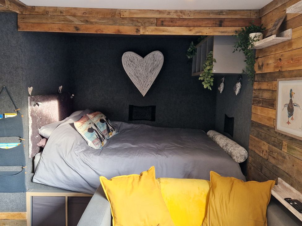 A bedroom with a bed and decorative pillows at Birdsong lodge near Hawthorn Farm near Sutton-On-Sea