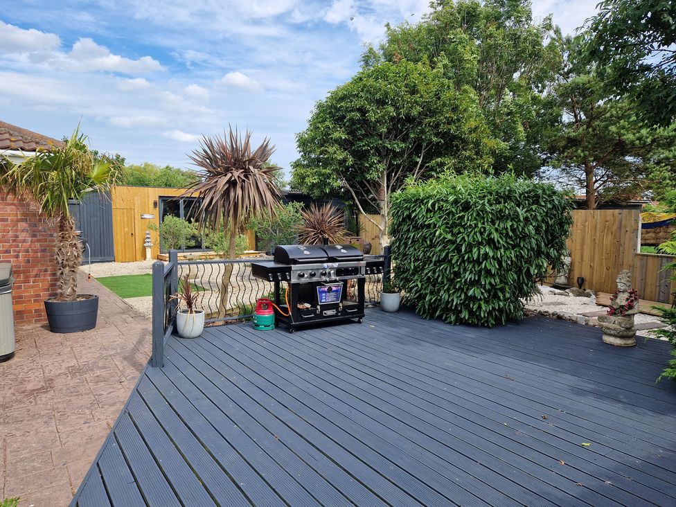 An outdoor area with a barbecue grill and decking at Birdsong lodge near Hawthorn Farm near Sutton-On-Sea