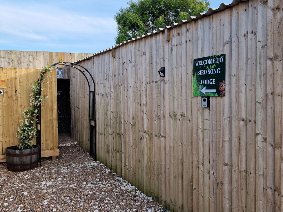 An entrance to Birdsong Lodge with an archway and a welcome sign at Birdsong Lodge Hawthorn Farm near Sutton-On-Sea