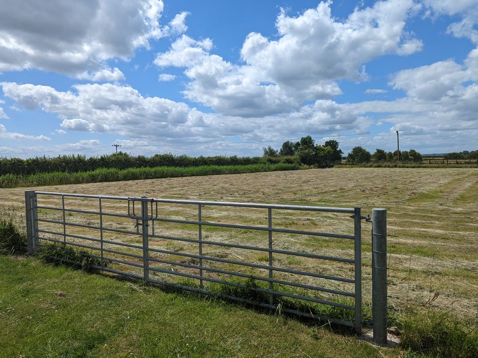 A field with a gate and hedges at Birdsong lodge near Hawthorn Farm near Sutton-On-Sea