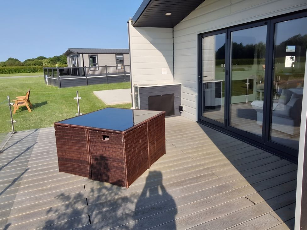 A deck with a table and seating at Waterside Lodge in Mablethorpe