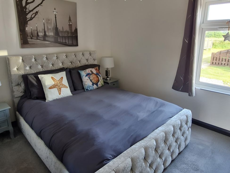 A bedroom with a bed and nightstand at Waterside Lodge in Mablethorpe