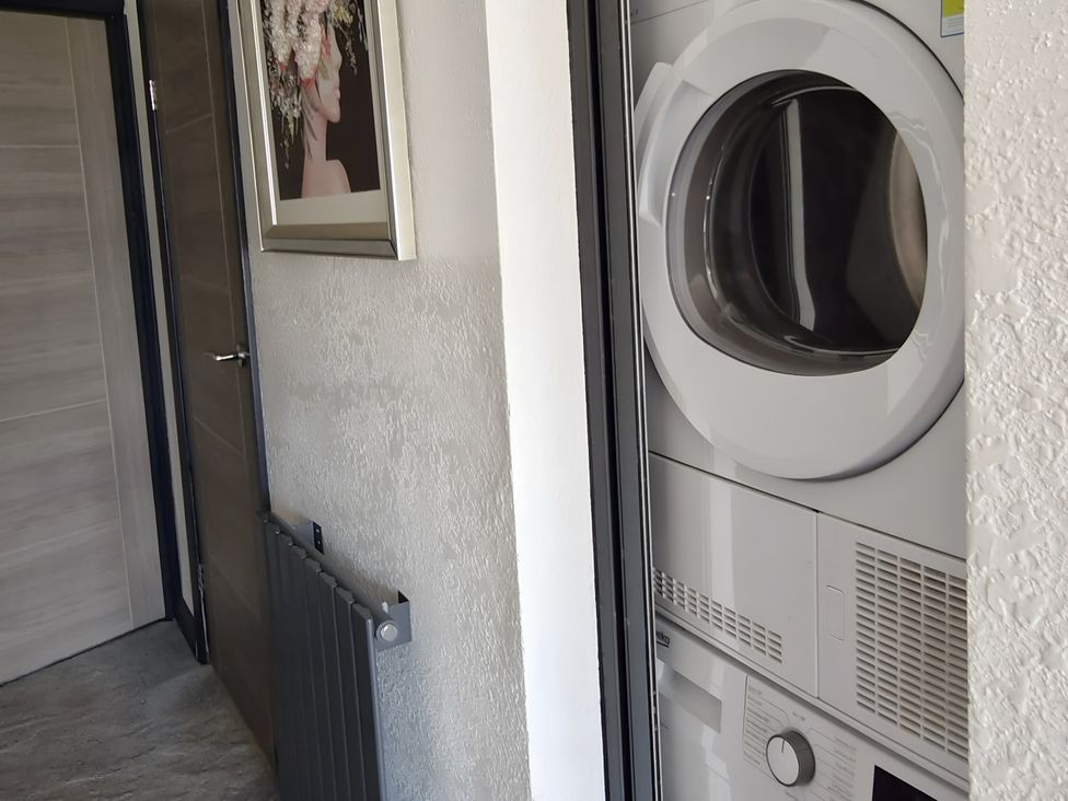 A laundry room featuring a door and a dryer at Waterside Lodge in Mablethorpe