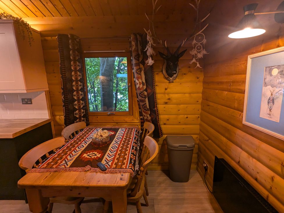 A dining room with a wooden table and chairs at Pineshadow Lodge in Louth