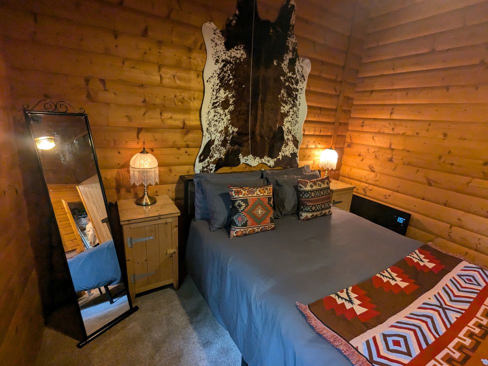 A bedroom with a bed and decorative pillows at Pineshadow Lodge in Louth