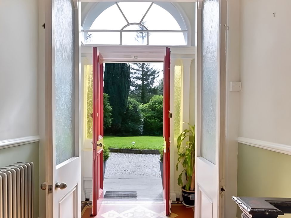 An entrance hall with front doors opening to a garden at Fountain Hill House Londonderry