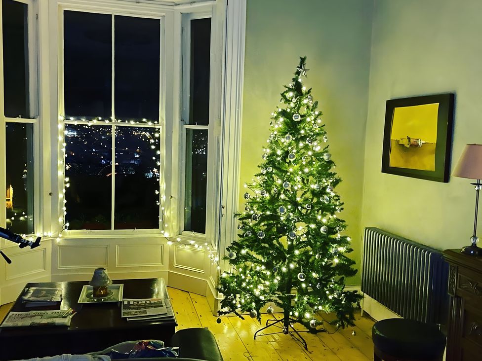 A living room with a Christmas tree and fairy lights at Fountain Hill House Londonderry