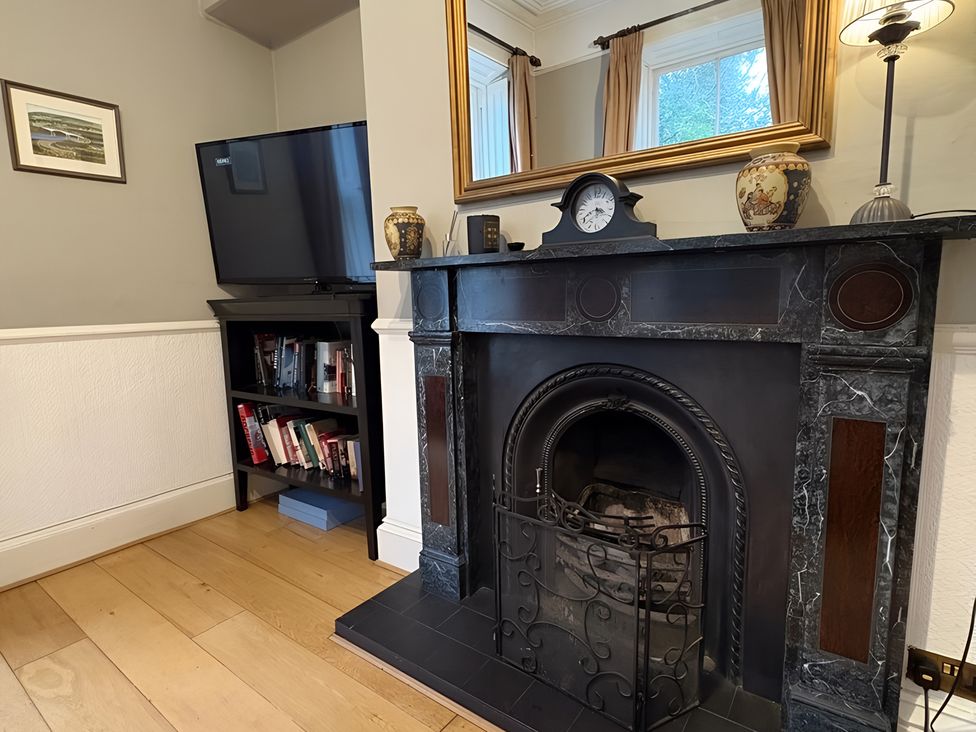 A living room with a fireplace and television at Fountain Hill House Londonderry