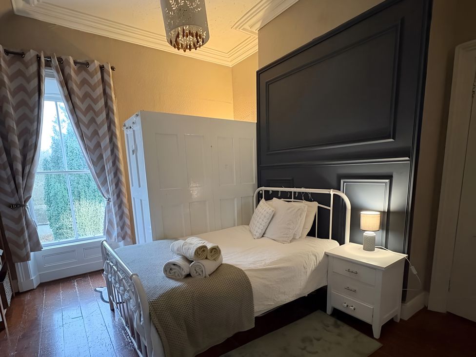 A bedroom with a bed and nightstand at Fountain Hill House Londonderry