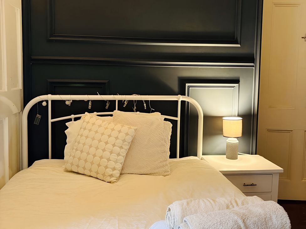 A bedroom with a bed and a lamp at Fountain Hill House in Londonderry