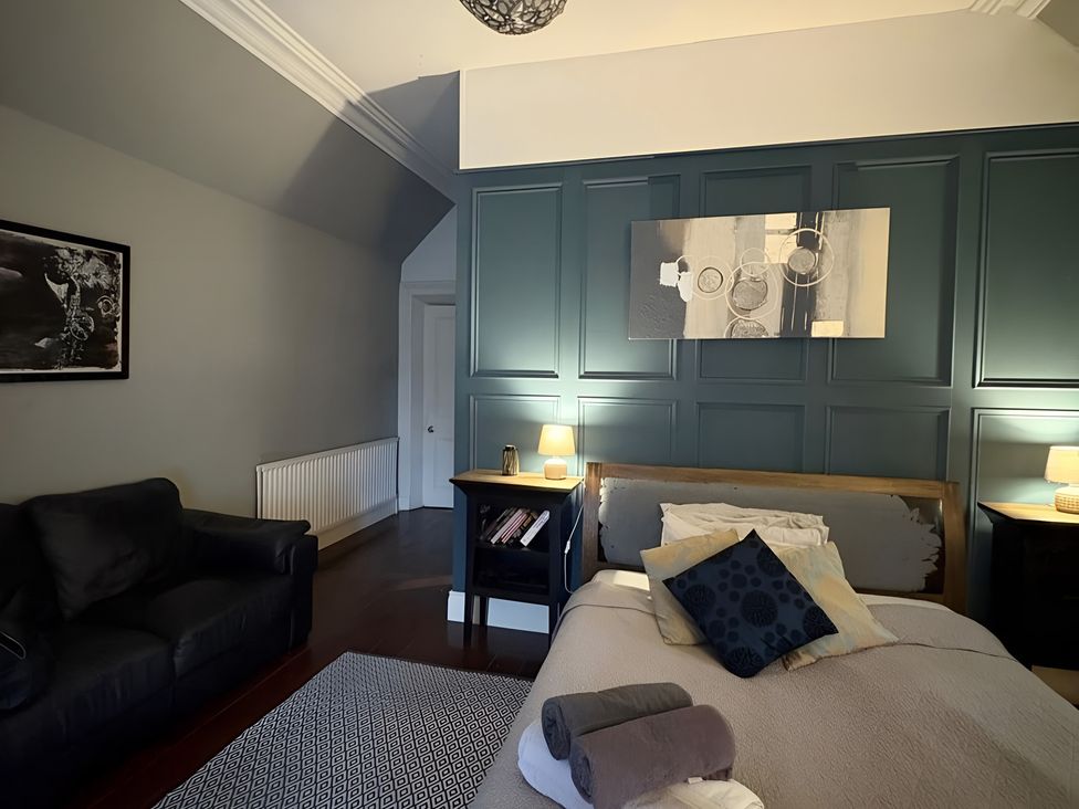 A bedroom with a bed and sofa at Fountain Hill House in Londonderry