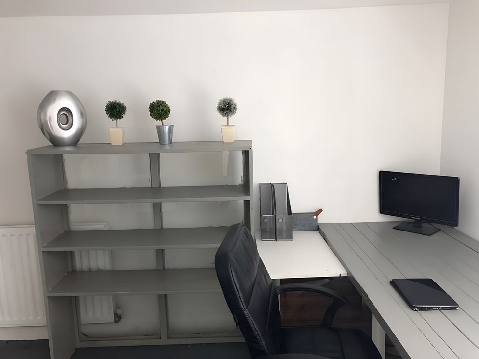 An office with a desk, computer monitor, and decorative plants at Fountain Hill House Londonderry