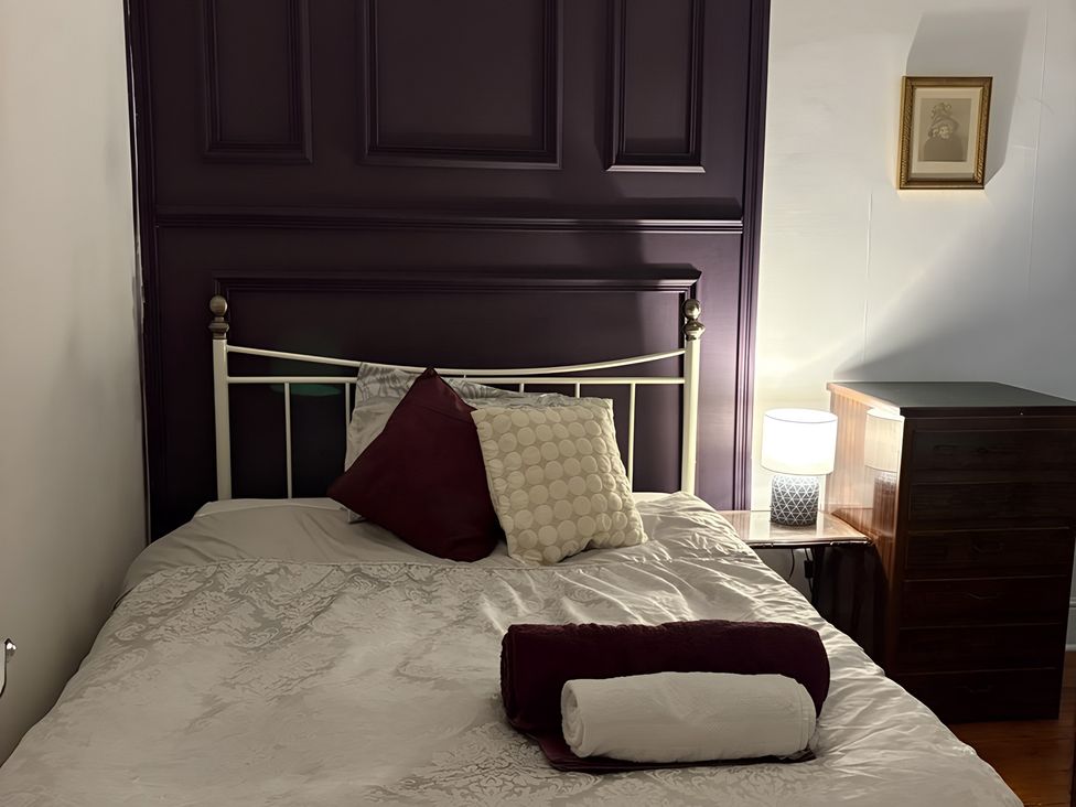 A bedroom with a bed and bedside table at Fountain Hill House Londonderry