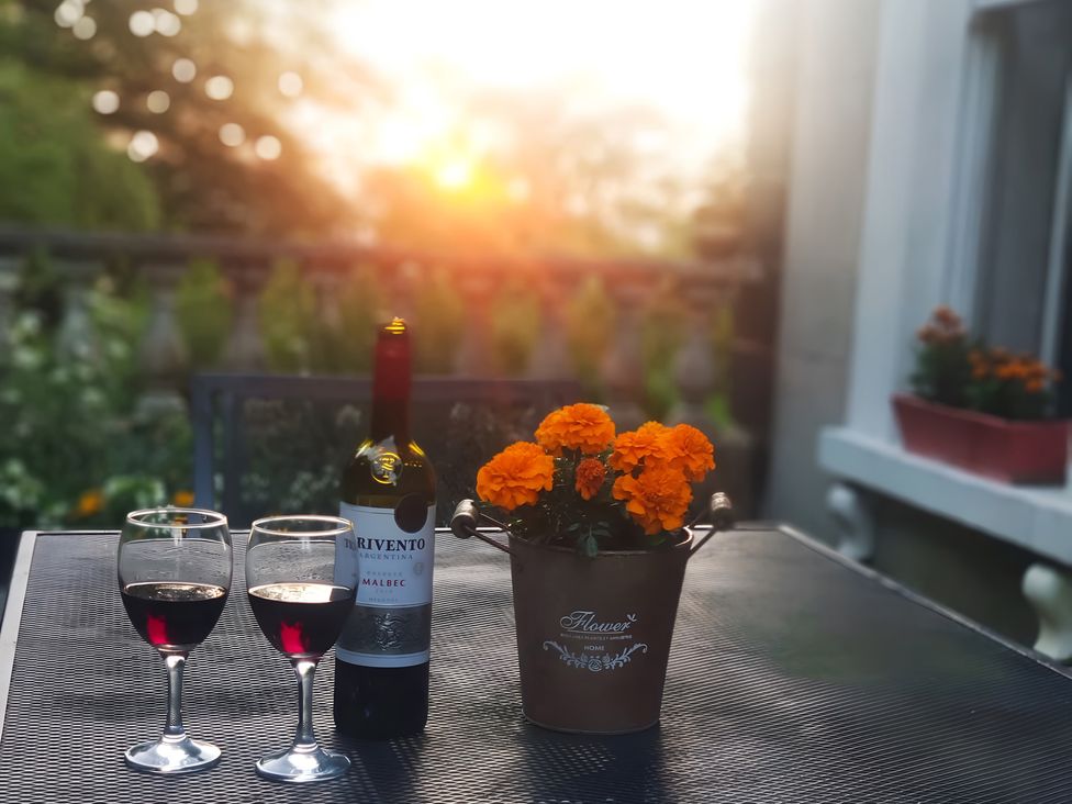A table with wine glasses and flowers at Fountain Hill House in Londonderry