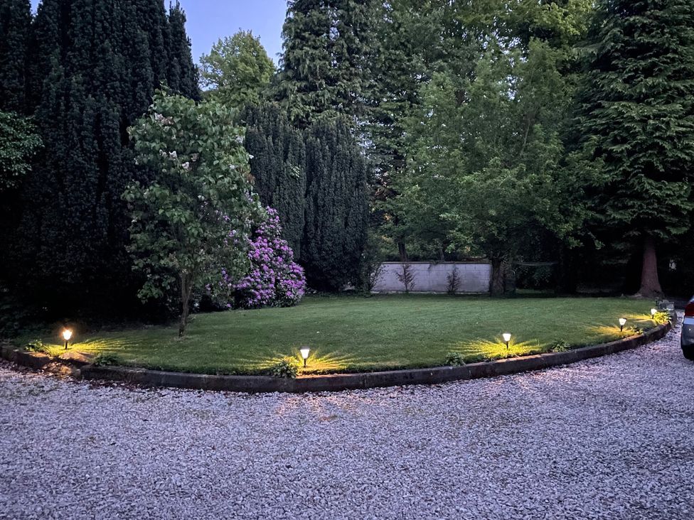 A garden with grass and trees at Fountain Hill House in Londonderry