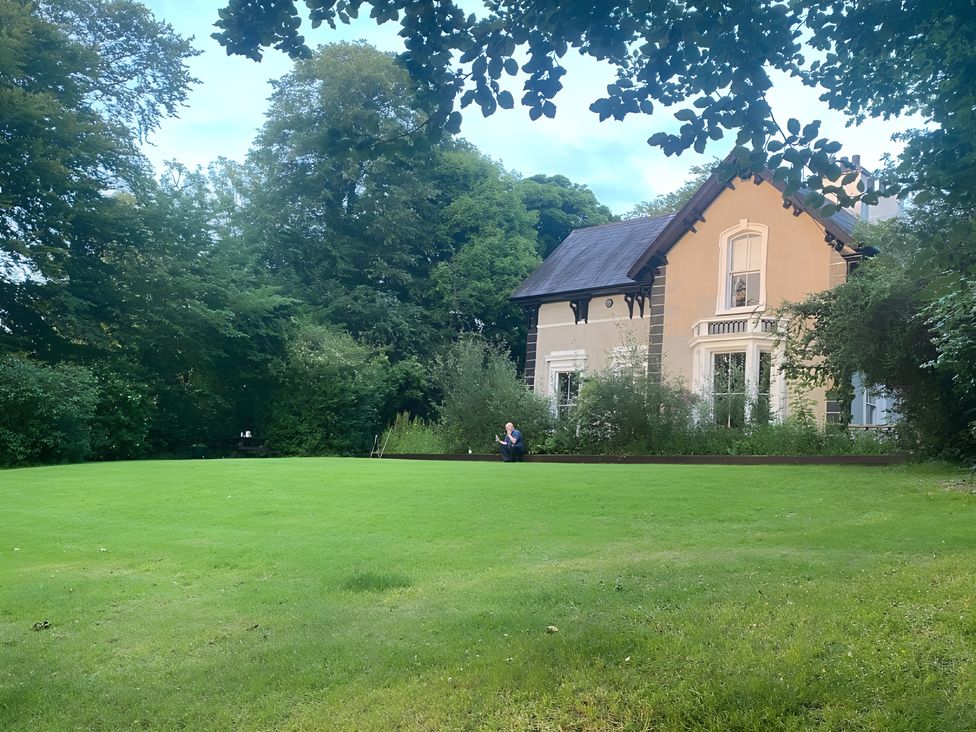 A garden with a house surrounded by grass and trees at Fountain Hill House Londonderry