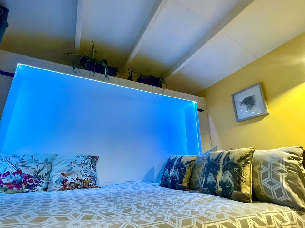 A bedroom with a bed and pillows at Bluebell Shepherd’s Hut in Llanfairpwllgwyngyll