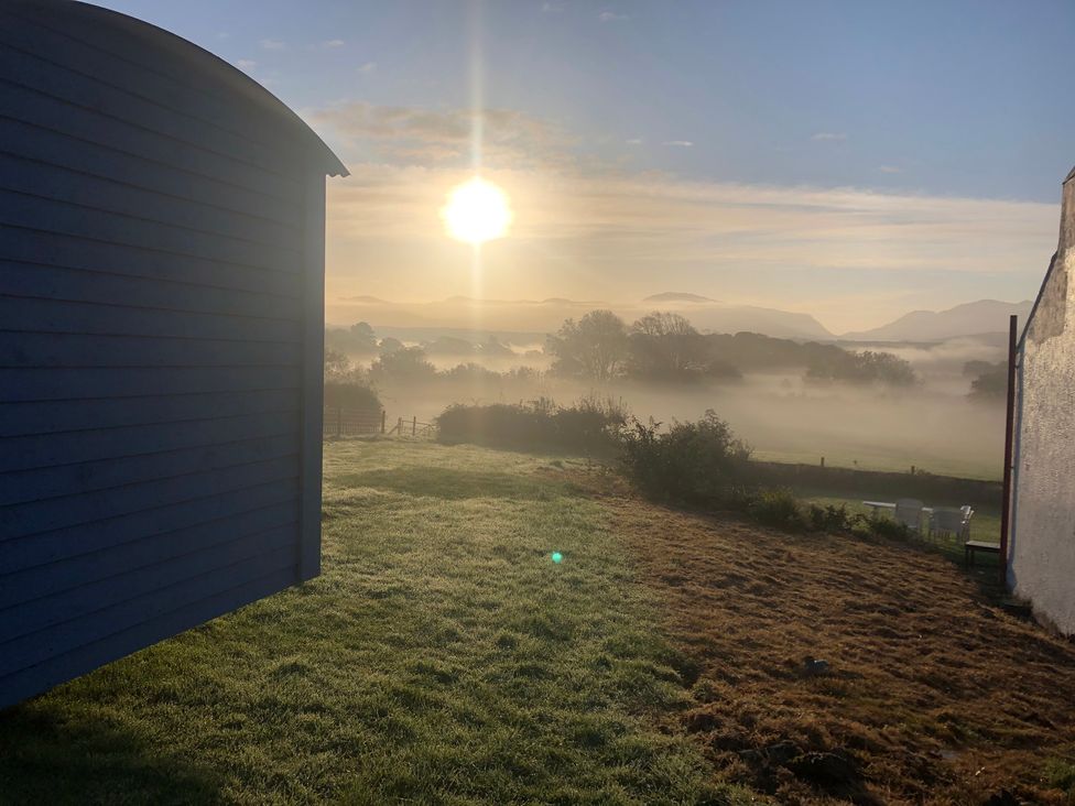 A view of sunrise with fog and grass at Bluebell Shepherd’s Hut in Llanfairpwllgwyngyll