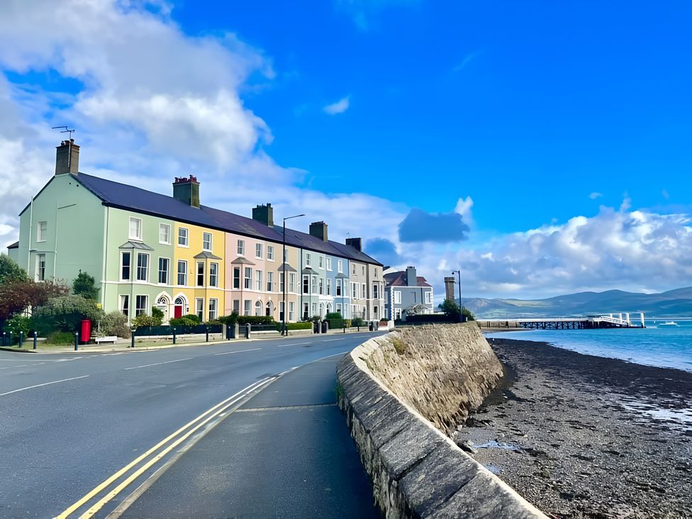A row of houses along a road near water at Bluebell Shepherd’s Hut in Llanfairpwllgwyngyll