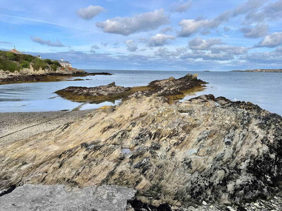 A shore with rocks and water at Bluebell Shepherd’s Hut in Llanfairpwllgwyngyll