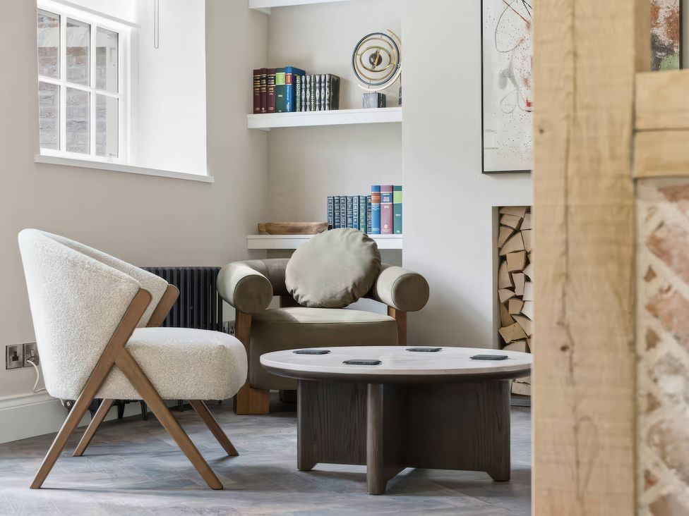 A sitting room with a coffee table and books on a shelf at Apt.1 
