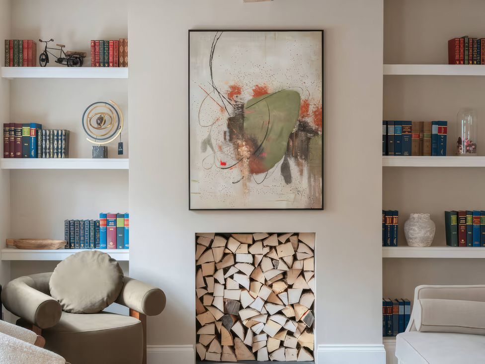 A living room with bookshelves and stored firewood at Apt.1 