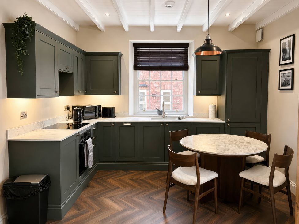 A kitchen with cabinets and a dining table at Apt.1