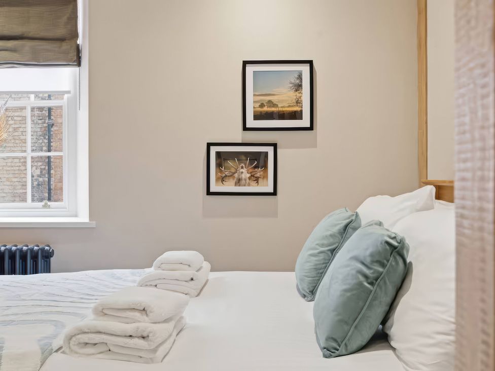 A bedroom with a bed and photographs on the wall at Apt.1 