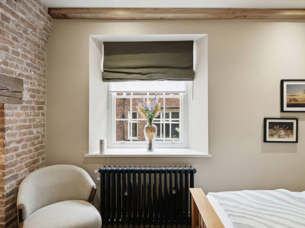 A bedroom with a window and a chair at Apt.1 in 